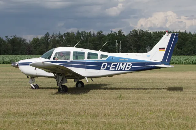 Beechcraft C24R Sierra D-EIMB viewed from the side on a grass airfield.