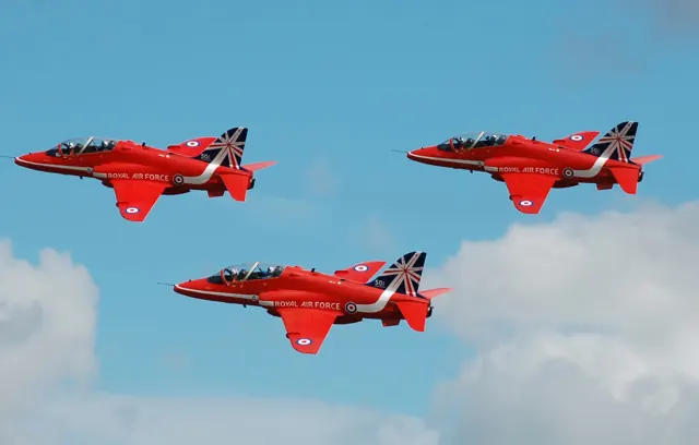 The RAF Red Arrows depart the 2014 Royal International Air Tattoo , England , in a colour scheme that commemorates their 50th year.