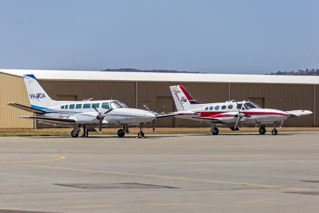 A Cessna 404 Titan (left) with square windows beside a pressurized Cessna 421 (right) with round windows