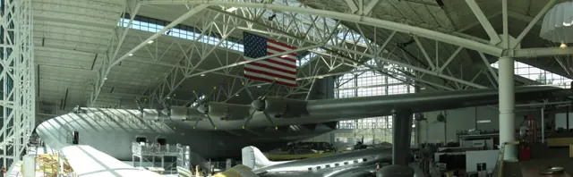 H-4 Hercules at North American Aerospace Museum. A Douglas DC-3 parked beneath its wing shows the scale of the H-4.